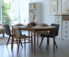 Beautiful table setting, chairs and decor in dining room. Interior design