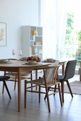 Beautiful table setting, chairs and decor in dining room. Interior design