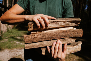 Lumberjack carrying firewood in forest: sustainable forestry practices