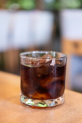 A glass of Cola on the table with bokeh background