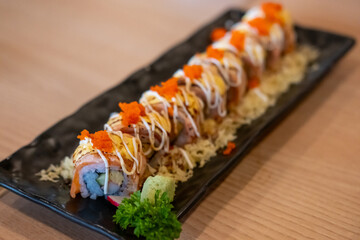 Burned Salmon Sushi roll with cheese served on plate