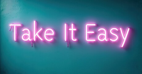 Bright pink neon sign displays text Take It Easy against teal wall. Simple message, modern aesthetic, vibrant colors.