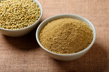 Indian spices called coriander and coriander powder on jute background 