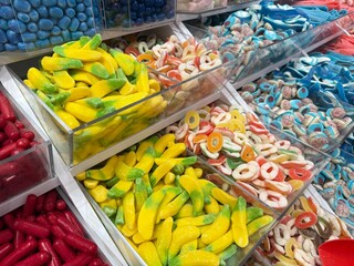 A colorful and inviting candy shop filled with jars, shelves, and displays of sweets, lollipops, and chocolates. A cheerful atmosphere that evokes childhood joy, indulgence, and festive celebration