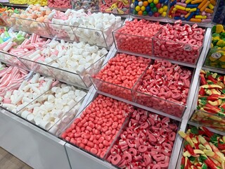 A colorful and inviting candy shop filled with jars, shelves, and displays of sweets, lollipops, and chocolates. A cheerful atmosphere that evokes childhood joy, indulgence, and festive celebration