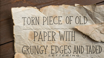 Torn grunge old paper with text and wavy lines on wooden background texture