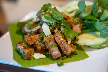 Spicy crispy pork salad or Larb. Thai food, served on plate.