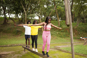Naklejka premium Two ladies and a man exercising in the park