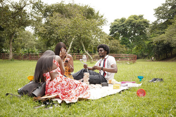 Three friends having a picnic at the park on a bright summer day 