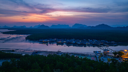 Aerial view of scenery sky reflection at Bang Phat fishing village at twilight. Reflection of the dusk sky in a fishing village living on a small, isolated island surrounded by mangrove forests.