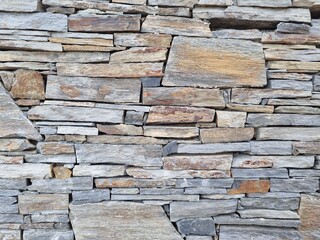 Fototapeta premium Rustic stone wall texture made of stacked natural rocks. Perfect background for design, 3D modeling, architecture, interiors, exteriors, game assets, and creative projects.