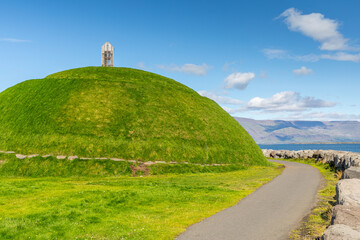 Butte verte de Þúfa, surmontée d'une cabane pour faire sécher le poisson, située à l'embouchure de la baie de Faxa, sur le port de Reykjavik, en Islande