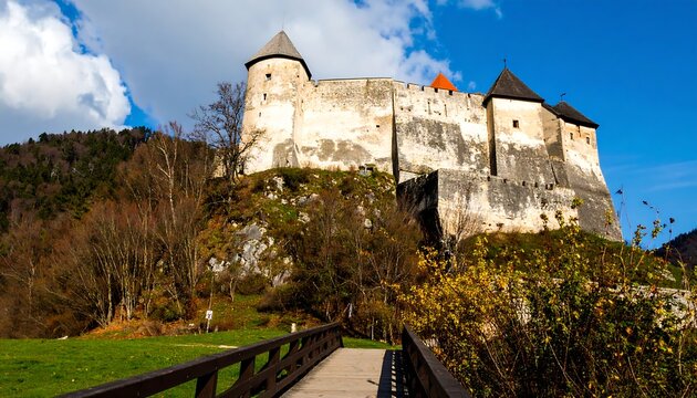 A majestic ancient stone castle stands proudly on a hilltop overlooking a tranquil valley.