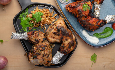 Crispy delicious chicken tandoori and Afghani chicken tandoori  with salad served in plate. Tandoori Chicken is an Indian non vegetarian spicy food