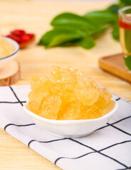 Yellow Rock Sugar Crystals Made from Sugar Cane in White Bowl on Kitchen Table