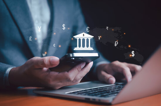 Businessman using smartphone, laptop with global banking icon, currency symbol, representing digital finance, online banking, fintech, money transfer, investment, international financial technology. - Powered by Adobe