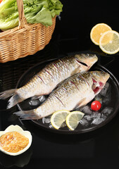 Fresh whole carp fish on ice with lemon and vegetables - raw seafood cooking ingredients