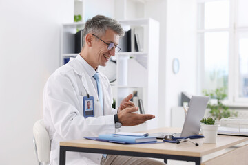 Telemedicine. Doctor having video call with patient via laptop indoors