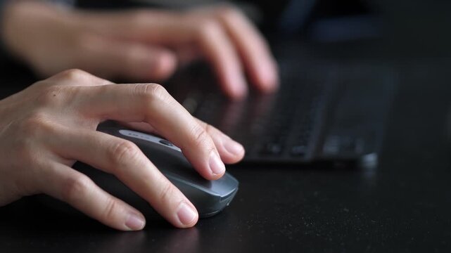 Close-up of hand using computer mouse while working at desk