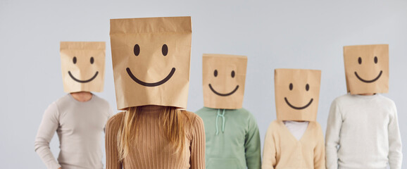 Group of unidentified people carry paper bags with smiley emoticons painted on heads. Portrait of...