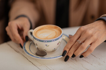 Female hands and cup of coffee on the table