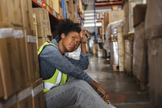 Tired stress young teen women worker labor rest in factory warehouse cargo inventory industry.