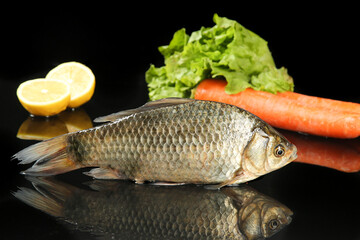 Fresh Whole Carp Fish with Vegetables and Lemon on Black Background for Cooking