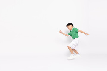 Happy Asian cute little boy in a green sports jersey running so fast isolated on white background