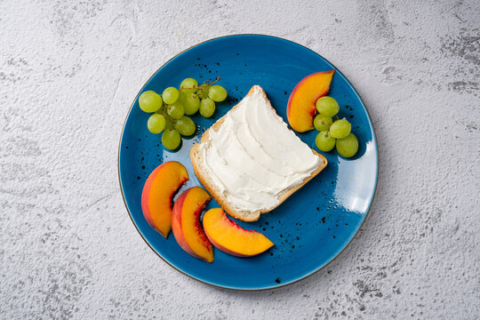 Breakfast plate with cream cheese toast, grapes, and peach slices