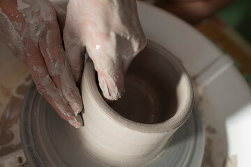 Manos trabajando la ceramica en el torno