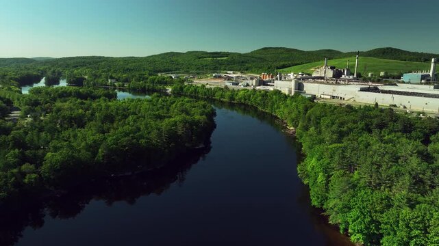 Industrial plant with water treatment ponds, river, and forest in USA