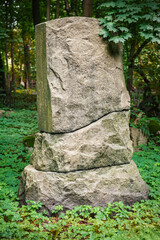 Large stone rough monument stands in forest landscape