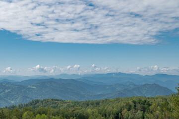 The mountain tops are covered with snow and illuminated by the reddish morning light.