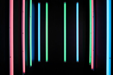 Abstract Colorful Neon Light Installation with Pink Green and Blue Fluorescent Tubes on Black Background Illuminating a Modern Space