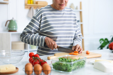 Fototapeta premium Senior woman cooking at white marble table in kitchen, closeup