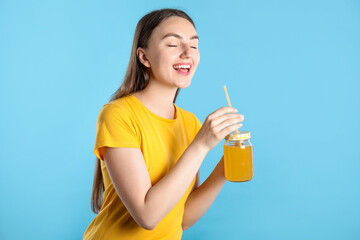 Woman with refreshing drink and straw on light blue background