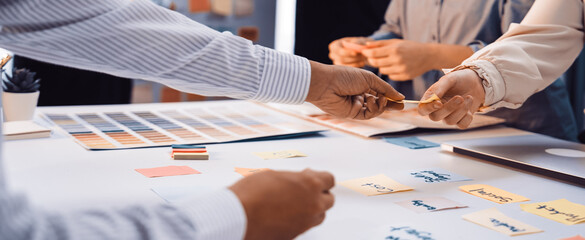 Collaborative brainstorming session with sticky notes and color palettes showcasing team interaction and creative planning in a modern workspace environment SACTR