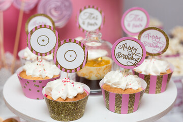 Fun birthday cupcakes decorated with “Happy Birthday” toppers in pink and gold striped wrappers. Perfect for festive celebrations and sweet tables.