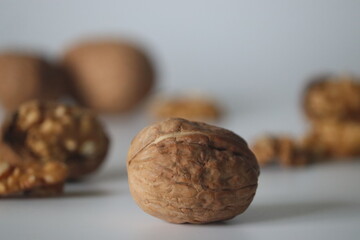 Walnuts in sharp foreground with shelled pieces blurred behind. Winter snack theme health, texture
