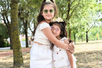 Fototapeta premium Happy and smiling two little sisters outdoors having fun