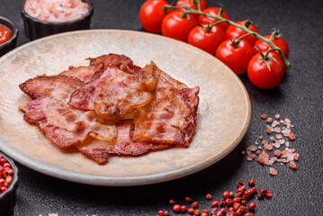 Cooked crispy fried pork bacon strips for a hearty breakfast. Fried bacon strips
