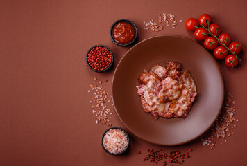 Cooked crispy fried pork bacon strips for a hearty breakfast. Fried bacon strips