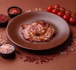 Cooked crispy fried pork bacon strips for a hearty breakfast. Fried bacon strips