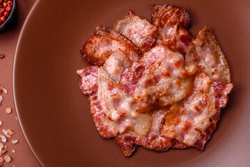 Cooked crispy fried pork bacon strips for a hearty breakfast. Fried bacon strips