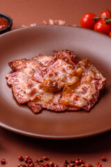 Cooked crispy fried pork bacon strips for a hearty breakfast. Fried bacon strips