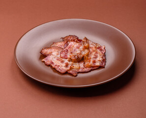 Cooked crispy fried pork bacon strips for a hearty breakfast. Fried bacon strips