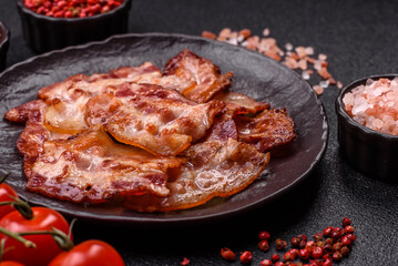 Cooked crispy fried pork bacon strips for a hearty breakfast. Fried bacon strips