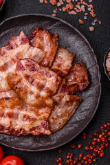 Cooked crispy fried pork bacon strips for a hearty breakfast. Fried bacon strips