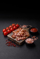 Cooked crispy fried pork bacon strips for a hearty breakfast. Fried bacon strips