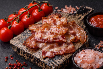 Cooked crispy fried pork bacon strips for a hearty breakfast. Fried bacon strips